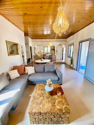 a living room with a blue couch and a table at Villa Elena - Private Villa in the heart of nature in Chania Town