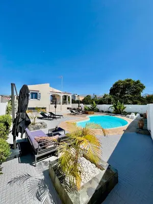 a patio with a pool and a chair and a palm tree at Villa Elena - Private Villa in the heart of nature in Chania Town