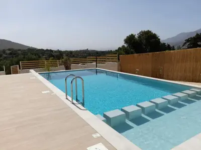 a swimming pool in a backyard with a wooden fence at Villa Dedalos in Kalamitsi Amygdali