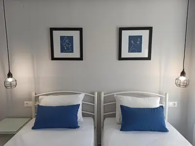 a bedroom with two beds with blue and white pillows at Villa Dedalos in Kalamitsi Amygdali