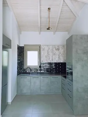 a large kitchen with a sink and a window at Villa Dedalos in Kalamitsi Amygdali