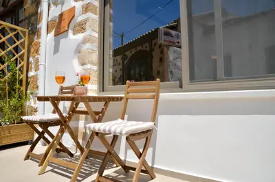 a table with two chairs and two glasses of wine at VAMA APARTMENT in Plataniás