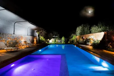 a swimming pool at night with purple lights at Casa Regno in Ayiá
