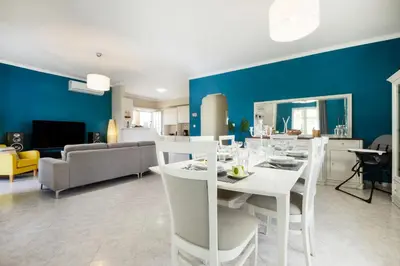 a dining room and living room with a white table and chairs at Casa Regno in Ayiá