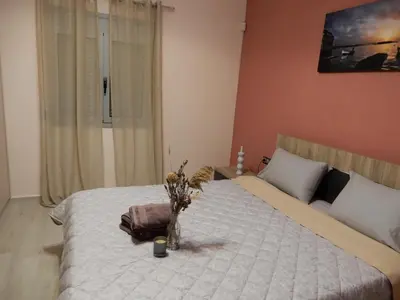 a bedroom with a bed with a bag and flowers on it at Royal Legend Suite in Souda