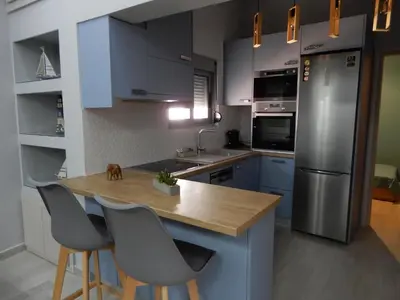 a kitchen with blue cabinets and a wooden counter top at Royal Legend Suite in Souda