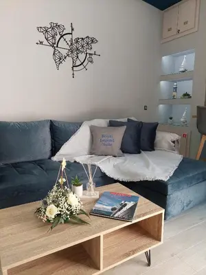 a living room with a blue couch and a coffee table at Royal Legend Suite in Souda