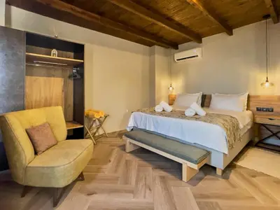 a bedroom with a bed and a chair at INO III Domus SWIMSPA by Amigdalokefali Elafonissi in AmigdhalokeFálion
