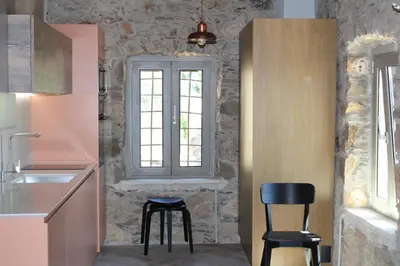 a kitchen with two stools and a window at INO III Domus SWIMSPA by Amigdalokefali Elafonissi in AmigdhalokeFálion