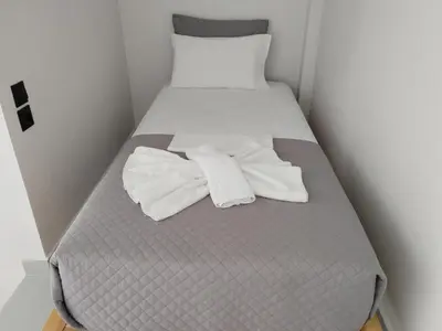 a bed with two white towels sitting on it at Zorbas in Sougia