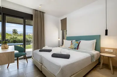 a bedroom with a bed and a desk and a window at Iniada Villas in Chania Town