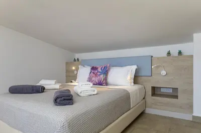 a bedroom with a bed with towels on it at Iniada Villas in Chania Town