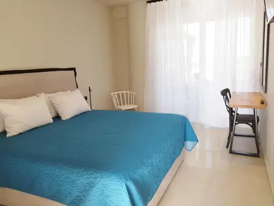 a bedroom with a blue bed and a chair and a window at Houmas Apartments in Yialós
