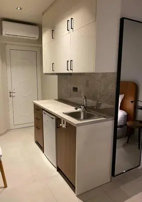 a kitchen with white cabinets and a sink at Houmas Apartments in Yialós