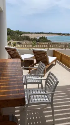 a group of chairs and tables on a balcony at Houmas Apartments in Yialós