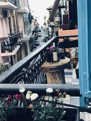 a balcony with a table and wine glasses on it at DIONI in Chania Town