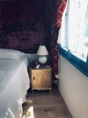 a bedroom with a bed and a lamp on a night stand at DIONI in Chania Town