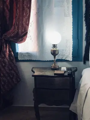 a lamp on a table next to a bed at DIONI 2 in Chania Town