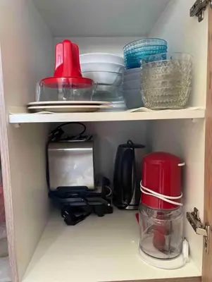 a cupboard with a microwave and some dishes at Haroupia in Elafonisi