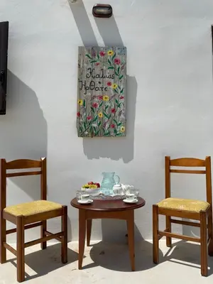 a table with two chairs and a table with a plate of food at Haroupia in Elafonisi