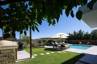 a backyard with a hammock and a swimming pool at Belair villas in Chania Town