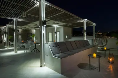 a couch sitting on a patio at night at xSuites - Adults Only Boutique Suites with Private Jacuzzi in Agia Marina Nea Kydonias