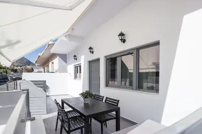 a patio with a black table and chairs at Villagio House in Falasarna