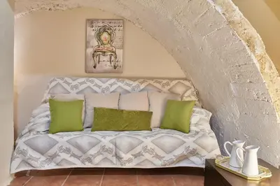 a white bed with green pillows in a room at Dreamscape Residences - Stavros Apartment in Chania Town