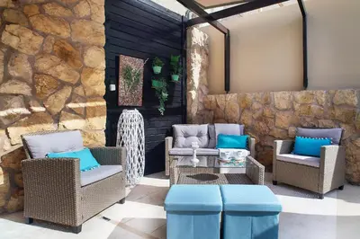a patio with chairs and tables and a stone wall at Dreamscape Residences - Stavros Apartment in Chania Town
