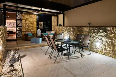 a table and chairs in a room with a stone wall at Dreamscape Residences - Stavros Apartment in Chania Town
