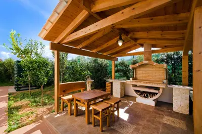 a wooden pavilion with a table and a grill at Villa Moma in Palio Gerani