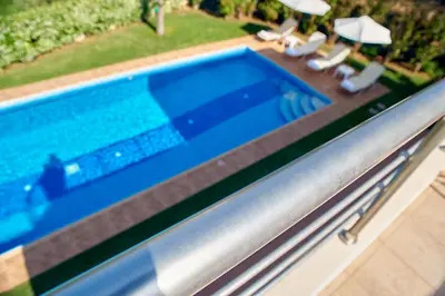 a swimming pool with chairs and umbrellas at Villa Moma in Palio Gerani