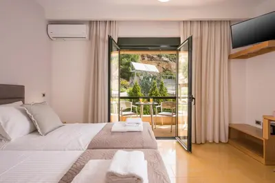 a bedroom with a bed and a balcony at Villa City View - Heated Pool & Gym - Majestic views - 5 min drive from center in Chania Town