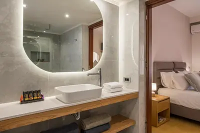 a bathroom with a sink and a mirror and a bed at Villa City View - Heated Pool & Gym - Majestic views - 5 min drive from center in Chania Town