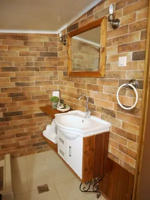 a bathroom with a sink and a brick wall at Casa di Portou No3 in Chania Town