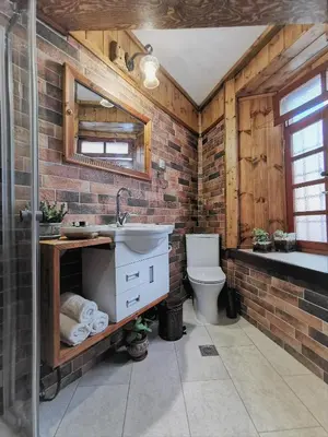 a brick bathroom with a sink and a toilet at Casa di Portou No3 in Chania Town