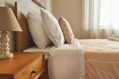 a bedroom with a bed with pillows and a table at evgenia's city apartment in Chania Town