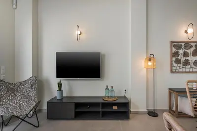 a living room with a flat screen tv on a wall at Kolymbari Sea Front Cozy Apartments in Kolymvari
