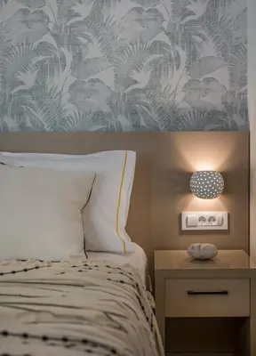 a bedroom with a bed and a table with a lamp at Kolymbari Sea Front Cozy Apartments in Kolymvari