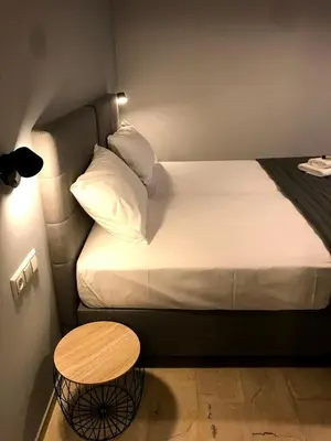 a small bedroom with a bed and a table at Tasoula's Beachside Rooms in Palaiochóra