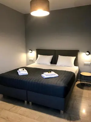 a bedroom with a bed with two towels on it at Tasoula's Beachside Rooms in Palaiochóra