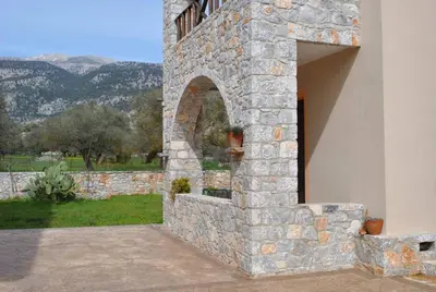 a building with a stone wall with a window at Xenonas Anopolis 2 in Anopoli Sfakion