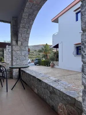 a stone wall with a table on a patio at Xenonas Anopolis 2 in Anopoli Sfakion