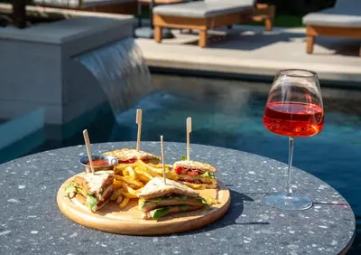 a sandwich and french fries on a table with a glass of wine at Eleanthi Modern Living in Galatás