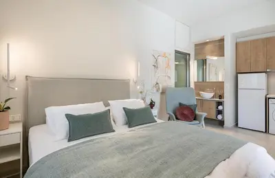 a bedroom with a large bed and a kitchen at Margiani Studio & Apartment in Chania Town
