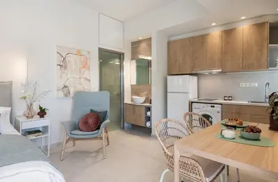 a kitchen and living room with a table and chairs at Margiani Studio & Apartment in Chania Town