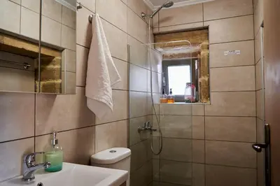 a bathroom with a sink and a toilet and a mirror at Studio Batilas in Kaláthenai