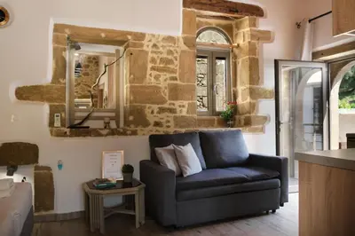 a living room with a couch and a mirror at Studio Batilas in Kaláthenai