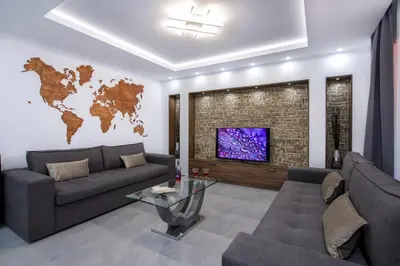 a living room with a couch and a tv with a map on the wall at TWIN'S HOME LUXURY SUITES in Alikianós