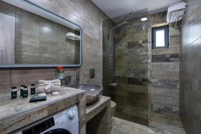 a bathroom with a sink and a shower at TWIN'S HOME LUXURY SUITES in Alikianós